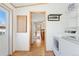Hallway leading to living spaces, including a laundry area with modern appliances at 2019 S Fox St, Denver, CO 80223