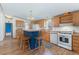 Modern kitchen featuring a breakfast bar, white appliances, and wood cabinets at 2019 S Fox St, Denver, CO 80223