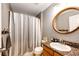 A cozy bathroom featuring a shower-tub, granite countertops, and a wood-framed mirror at 5794 S Yakima Way, Aurora, CO 80015
