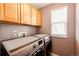 Convenient laundry room with washer, dryer, and upper cabinets at 5794 S Yakima Way, Aurora, CO 80015