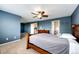 A spacious main bedroom features blue walls, carpet, and a ceiling fan at 5794 S Yakima Way, Aurora, CO 80015