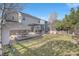 This backyard showcases the deck, outdoor dining area, green lawn, stone patio, and privacy fence at 23841 E Alabama Dr, Aurora, CO 80018