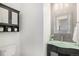 Powder room features glass bowl sink, decorative mirror, and cabinet storage at 23841 E Alabama Dr, Aurora, CO 80018