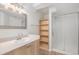 Bathroom featuring walk-in shower, wood shelf, and vanity sink at 23841 E Alabama Dr, Aurora, CO 80018