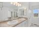 Bright bathroom featuring double sinks, a large mirror, and a separate tub and shower at 23841 E Alabama Dr, Aurora, CO 80018