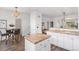 Open-concept kitchen with tile countertops, an island, white cabinetry, and barstool seating at 23841 E Alabama Dr, Aurora, CO 80018
