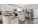 Bright kitchen with white cabinetry, stainless steel appliances, granite countertops, and hardwood floors at 23841 E Alabama Dr, Aurora, CO 80018
