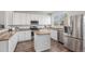 Modern kitchen features white cabinets, stainless steel appliances, and a kitchen island with granite countertops at 23841 E Alabama Dr, Aurora, CO 80018
