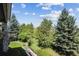 Beautiful backyard view featuring mature trees, lush landscaping, and glimpses of the surrounding community at 23545 E Phillips Pl, Aurora, CO 80016