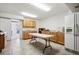 Large bonus room featuring wood cabinets, tile flooring, and a convenient refrigerator for versatile use at 23545 E Phillips Pl, Aurora, CO 80016