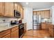 Well-equipped kitchen with wooden cabinets, stainless steel appliances, and tile backsplash at 23545 E Phillips Pl, Aurora, CO 80016