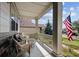 Inviting front porch with wicker furniture and American flag, perfect for relaxing at 23545 E Phillips Pl, Aurora, CO 80016