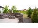 Beautiful backyard featuring a stone fire pit with seating, gravel beds, and lush greenery at 27655 E Geddes Pl, Aurora, CO 80016