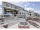 Exterior view of a home with a backyard fire pit and a stone seating area at 27655 E Geddes Pl, Aurora, CO 80016