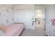 Bright bedroom with modern closet doors and a pink flower accent wall at 27655 E Geddes Pl, Aurora, CO 80016