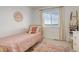 Bedroom featuring a pink quilt, a bright window, and mountain art piece at 27655 E Geddes Pl, Aurora, CO 80016