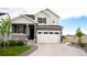 Charming two-story home featuring a covered porch, manicured lawn, and a two-car garage at 27655 E Geddes Pl, Aurora, CO 80016