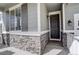 Stylish front door with stone accents and classic exterior lighting, adding to the home's curb appeal at 27655 E Geddes Pl, Aurora, CO 80016