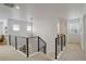 Bright hallway featuring modern railing, carpeted floors, and access to multiple rooms at 27655 E Geddes Pl, Aurora, CO 80016