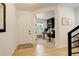 Inviting entryway with a view of the home office featuring custom green built-ins and bright natural light at 27655 E Geddes Pl, Aurora, CO 80016