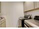Convenient laundry room with modern washer and dryer, plus storage cabinets at 27655 E Geddes Pl, Aurora, CO 80016