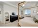 Bright main bedroom with a four-poster bed, black dresser and TV at 27655 E Geddes Pl, Aurora, CO 80016