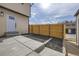 Backyard with a concrete patio, black mulch, and a wood fence under a partly cloudy sky at 11981 E Yale Ave, Aurora, CO 80014