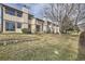 Townhome backyard features mature trees, grass, and a shared stone border wall at 11981 E Yale Ave, Aurora, CO 80014