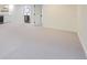 Open basement room with gray carpet and easy access to bathroom, bar area, and a hallway at 11981 E Yale Ave, Aurora, CO 80014