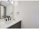 Stylish half-bath with a marble countertop, modern fixtures, and an arched mirror at 11981 E Yale Ave, Aurora, CO 80014