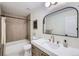 Modern bathroom with a shower-tub combo, new vanity, and a framed mirror at 11981 E Yale Ave, Aurora, CO 80014