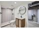 Basement bathroom features tiled shower, modern vanity, round mirror, and an open view of plumbing at 11981 E Yale Ave, Aurora, CO 80014