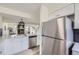 Bright, open kitchen featuring stainless appliances and white cabinets overlooking the living area at 11981 E Yale Ave, Aurora, CO 80014