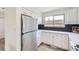 White kitchen featuring stainless steel appliances, quartz counters, and dark backsplash at 11981 E Yale Ave, Aurora, CO 80014