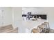 Modern kitchen with white cabinetry, a breakfast bar, and sleek black backsplash at 11981 E Yale Ave, Aurora, CO 80014
