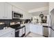 Bright kitchen with stainless steel appliances, white cabinets, and stylish backsplash at 11981 E Yale Ave, Aurora, CO 80014