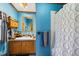 Bathroom features blue walls, wood trim, a wood vanity and a shower with a shower curtain at 7573 Woodruff St, Fort Lupton, CO 80621