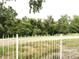 View of backyard with overgrown vegetation and a white fence at 1470 S Quebec Way # 275, Denver, CO 80231