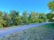 View of paved walking path through trees and greenery in the neighborhood with clear blue sky at 1470 S Quebec Way # 275, Denver, CO 80231