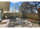 Private outdoor patio area with mature trees and metal furniture at 777 N Washington St # 204, Denver, CO 80203