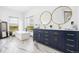 Bright bathroom featuring double sinks, a large tub, and modern fixtures on marble floors at 2400 Ventress Ct, Bennett, CO 80102