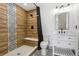 Stylish bathroom with wood-look tile shower, bench, and decorative tile accents at 2400 Ventress Ct, Bennett, CO 80102
