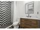 Well-lit bathroom featuring a modern vanity, hexagon tile flooring and decorative shower tile at 2400 Ventress Ct, Bennett, CO 80102