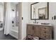 Bathroom with a modern vanity, mirror and shower/tub combo with elegant tile and black accents at 2400 Ventress Ct, Bennett, CO 80102
