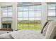 Bright bedroom featuring a scenic view through large windows, cozy bedding, and natural light at 2400 Ventress Ct, Bennett, CO 80102