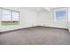 Bedroom features a neutral carpet, light paint and two large windows at 2400 Ventress Ct, Bennett, CO 80102