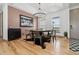 Dining area featuring an industrial-style chandelier, hardwood floors, and arched windows with views at 2400 Ventress Ct, Bennett, CO 80102
