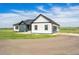 Well-maintained farmhouse with a mix of blue and white siding, a spacious driveway, and attached garage at 2400 Ventress Ct, Bennett, CO 80102