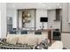 Kitchen with light gray cabinetry, wood island with seating, patterned backsplash, and stainless steel appliances at 2400 Ventress Ct, Bennett, CO 80102