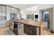 Kitchen with stainless steel appliances, a spacious island, and an adjacent dining area for convenient living at 2400 Ventress Ct, Bennett, CO 80102